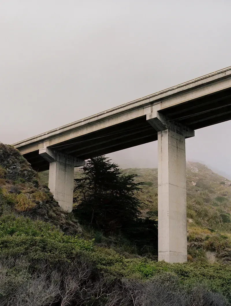Looking up at an elevated bridge on a foggy day