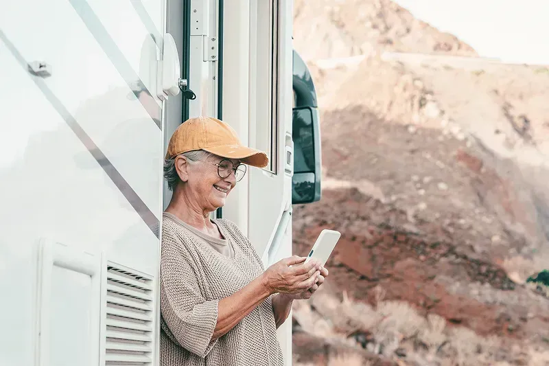Woman outside of an RV looking at her phone