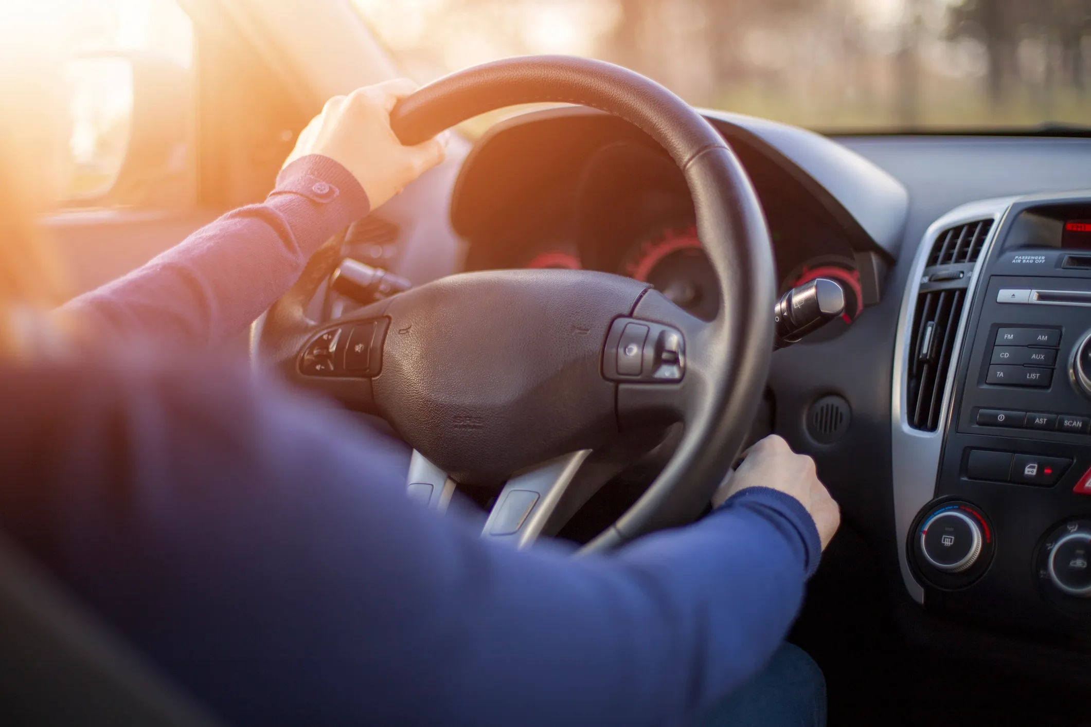A person inside their car turning the key to start the car.